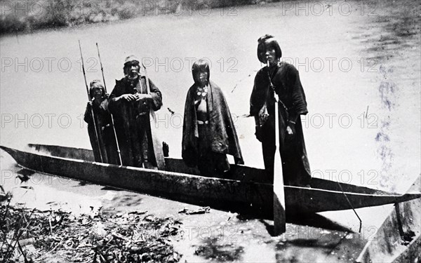 Photograph of Amazonian Indians in a dugout canoe