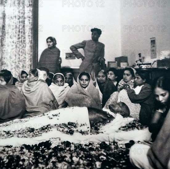 supporters surround the body of Gandhi before his cremation