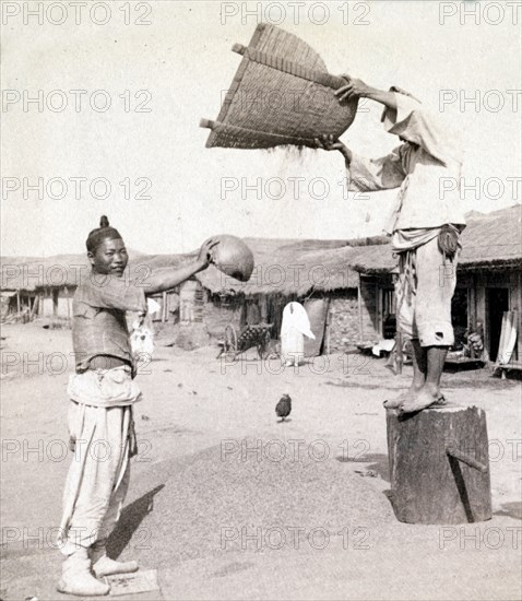 winnowing barley in the streets of Chemulop, Korea. Joseon Era