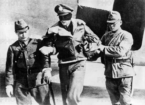 U.S. Army Air Force Lt. Robert L. Hite, blindfolded by his captors, is led from a Japanese transport plane