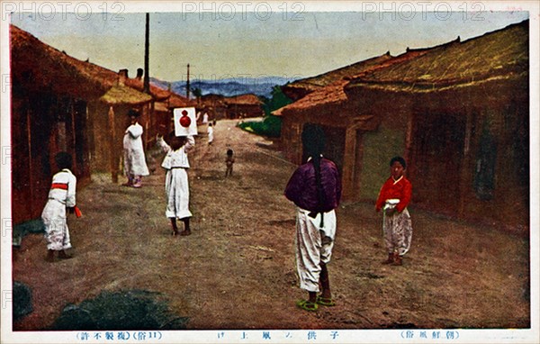 Korean children playing in a street with a kite. 1890