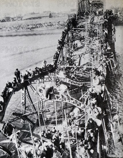 Korean War: Thousands of North Korean crossing a partly destroyed bridge on the Taedong River, fleeing Communist troops