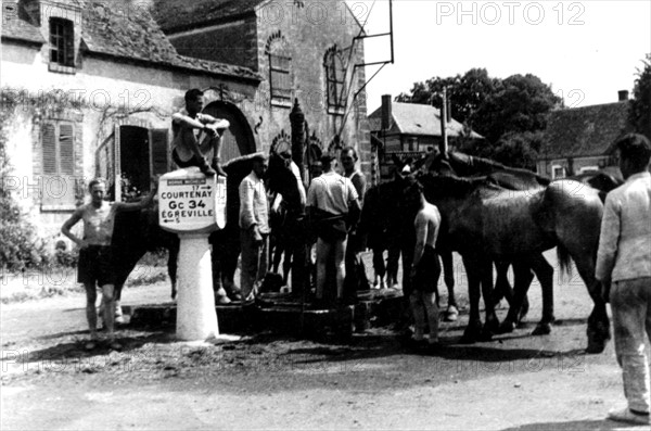 Soldats allemands faisant leur toilette dans la fontaine d'un village près de Courtenay, 1940