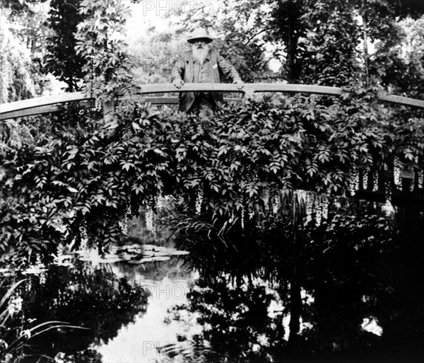 Painter Claude Monet on the waterlilies bridge, at Giverny
