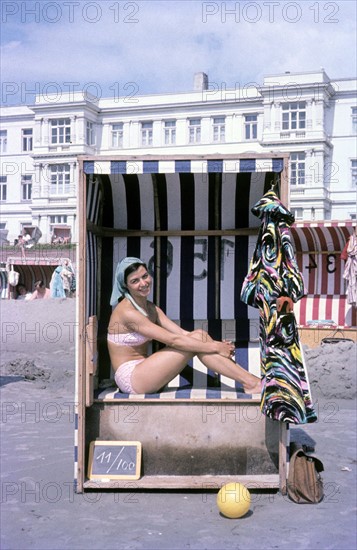 Femme en bikini dans un fauteuil-cabine en osier