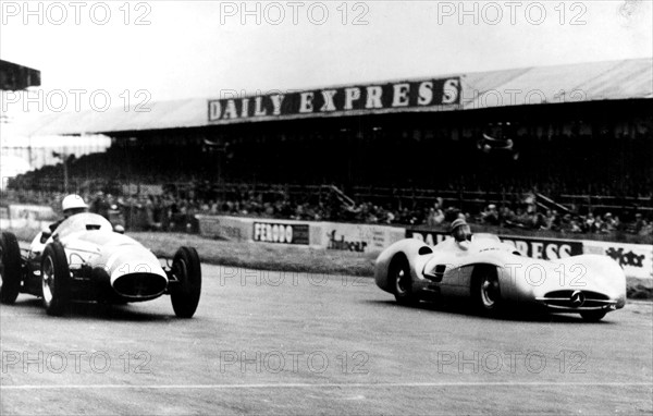 * 1911
Sportler, Rennfahrer; Argentinien

"Grosser Preis von England" in
Silverstone: Zweikampf zwischen Fangio
auf Mercedes Benz (r.) und dem Engl„nder
Stirling Moss vor der Haupttribne der
Silverstone - Rennstrecke.

- Juli 1954






autorennfahrer weltmeisterschaftslauf
tribne rennwagen silberpfeil grosse