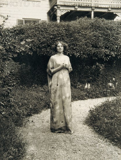 Emilie Floege in an artistic reform dress with floral pattern in the garden of the Oleander villa in Kammer at the Attersee lake. Photography, 1910.