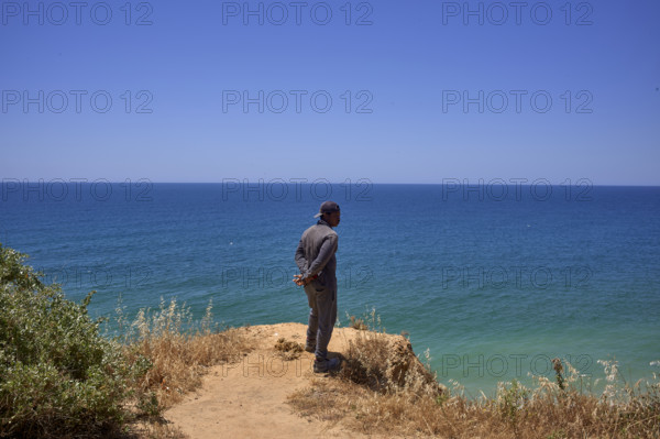 Un homme regarde la mer  en Algarve