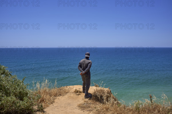 Un homme regarde la mer  en Algarve