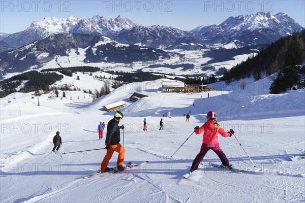 Skiers in front of alpine guesthouse Laerchfilz Hochalm