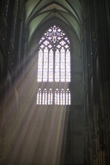 Rays of light fall through a coloured church window