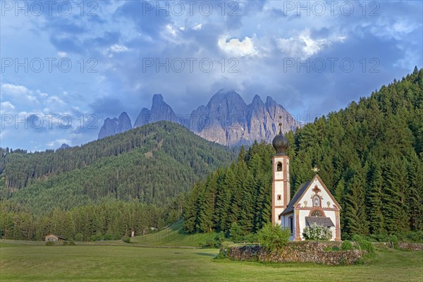 Church of St. Johann with cloudy Geislerspitzen in the background