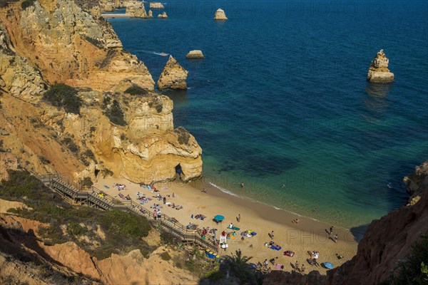 Swimmers on the beach between steep cliffs