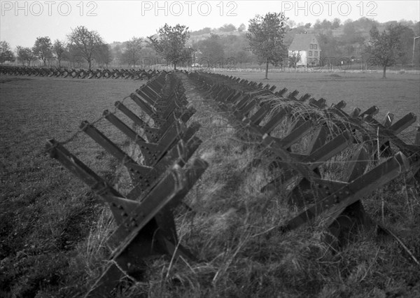 Tanks on a field at the edge of a settlement