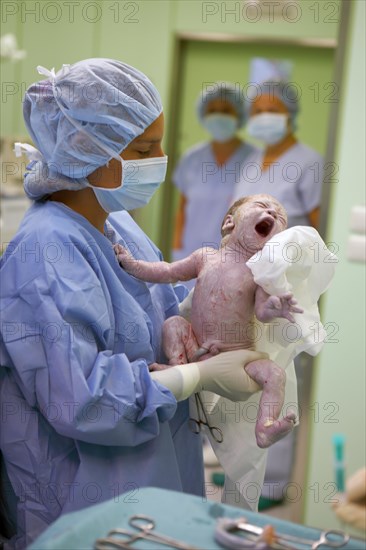 Nurse with newborn baby after Caesarean section