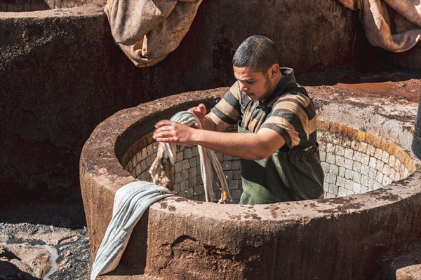 Worker dyeing leather