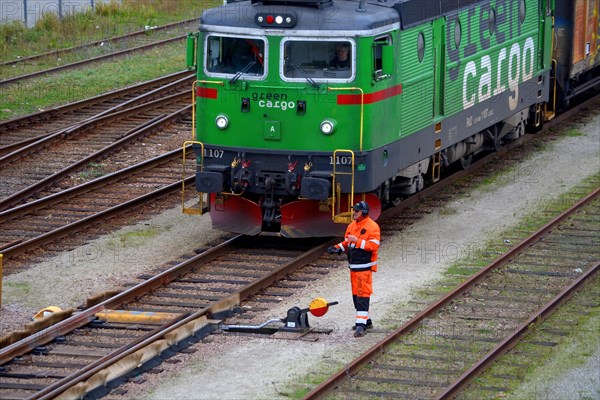 Railway worker waiting for cargo train's take off on railway station