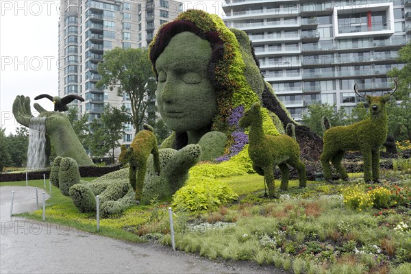 Plant sculpture Mother Earth with modern buildings behind