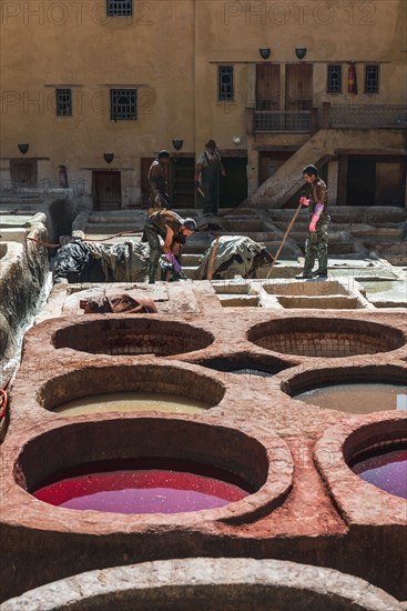 Worker dyeing leather