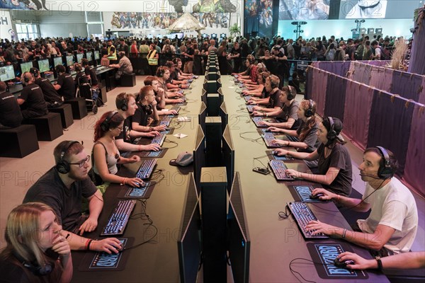 Visitors playing a computer game in front of screens