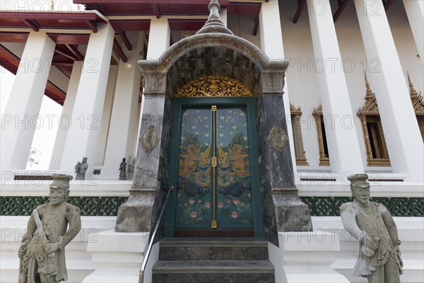 Painted door and stone figures in front of the Ubosot