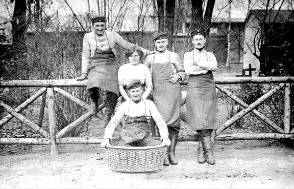 Four uniformed men and one woman pose in front of fence