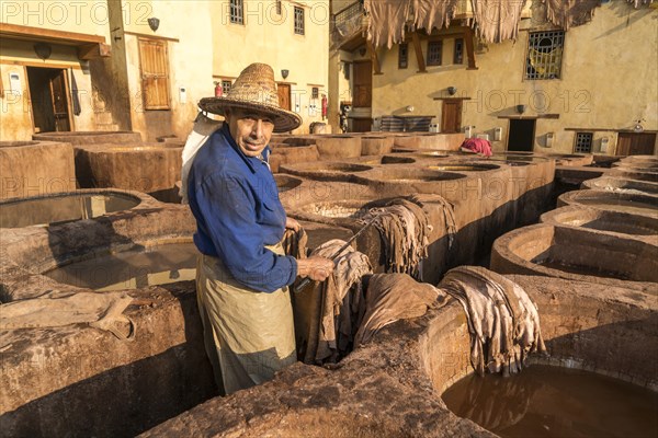 Leather tanners on tanks with paint for dyeing leather