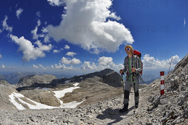 Mountaineer descending from the summit of the Hochkonig over the plateau of the Ubergossene Alm