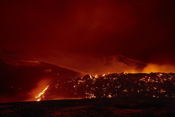 Glowing lava and lava flow at night at Fimmvorouhals volcano