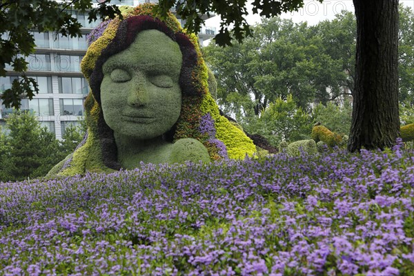 Plant sculpture Mother Earth with modern buildings behind