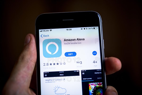 Hand holding iPhone with Amazon Alexa App in the Apple App Store
