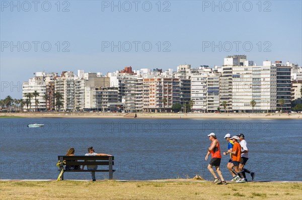 Joggers and people on a bench at the Rambla