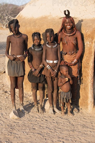 Himbafrau and children in front of a mud hut