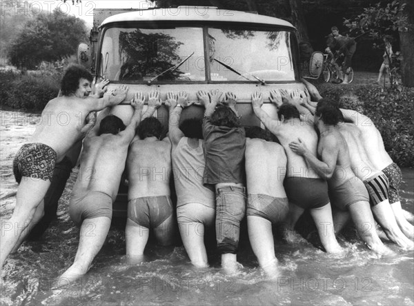 Men push car in water ca. 1970's