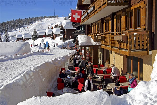 Restaurant terrace on the Dorfstrasse with snow-covered houses