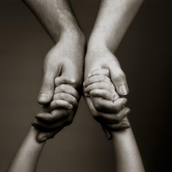 Child's and parents hands holding each other