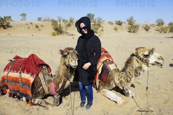 Tourist with resting camels on camel tour