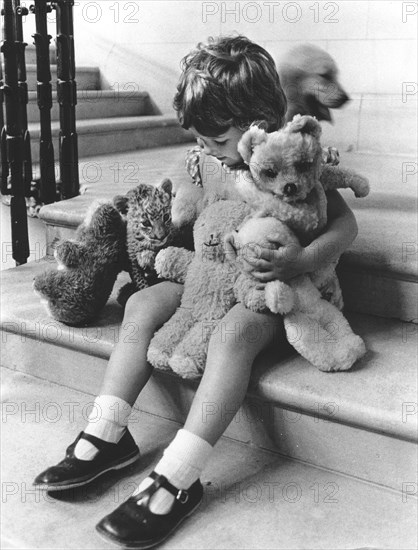 Girl plays with a baby predator and stuffed animals