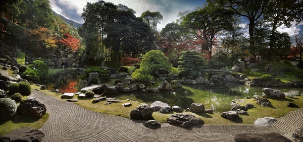 Traditional Japanese Zen rock garden with a pond and white pine trees