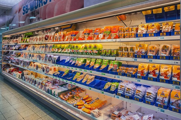 Shelf with packed sausages in supermarket