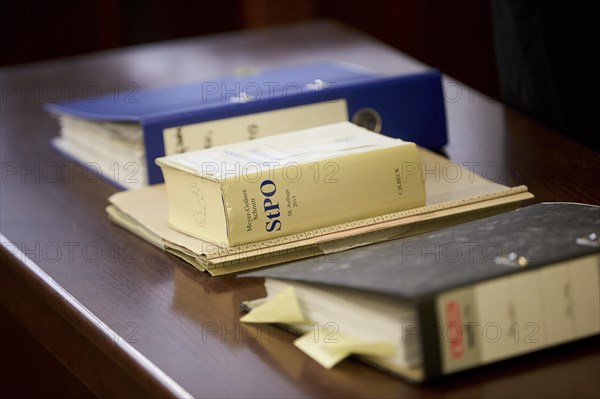 Trial files and Criminal Procedure Code StPO on the table in the courtroom