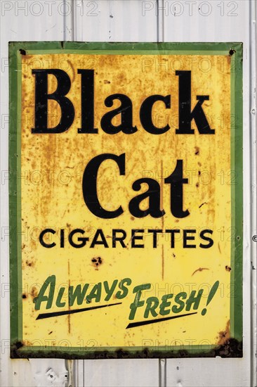 Closeup of Black cat cigarettes brand metal advertising sign