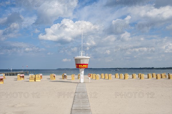 Empty sandy beach with DLRG monitoring tower and beach chairs