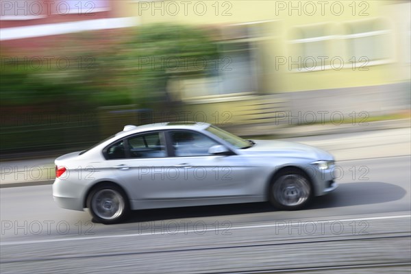 Car 3 Series BMW drives through residential area