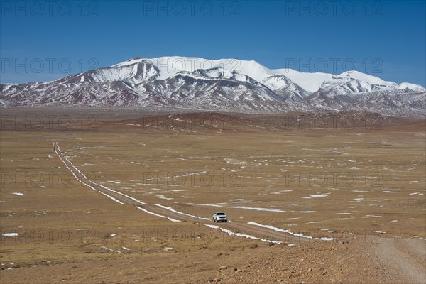 Trail with Landcruiser in front of Mount Amu Kangri