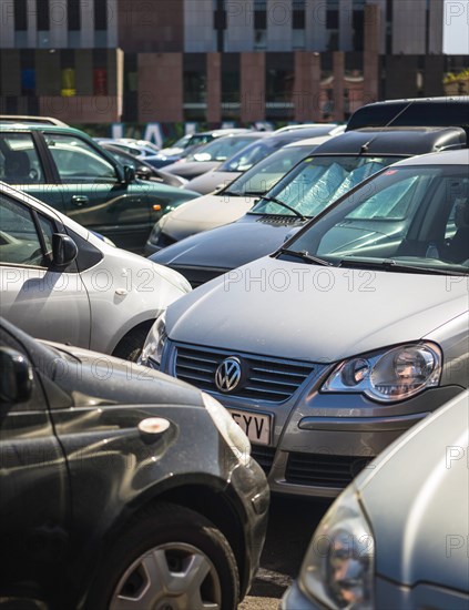 Many cars close in line on a parking lot