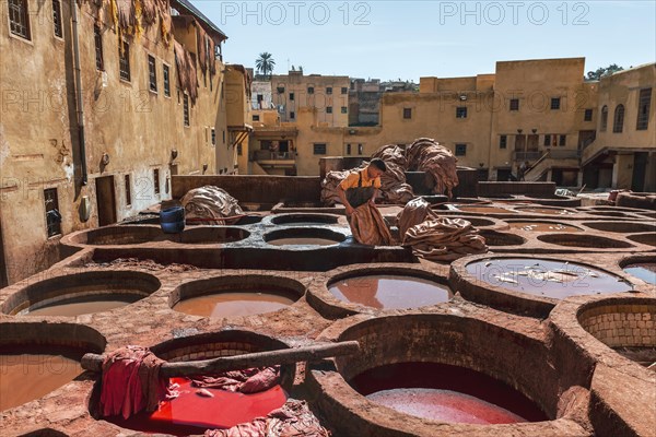 Worker dyeing leather