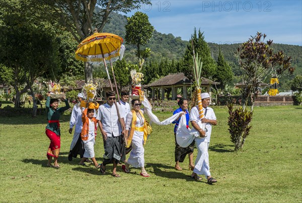 Procession of devout Buddhists at water temple Pura Ulun Danu Bratan water temple