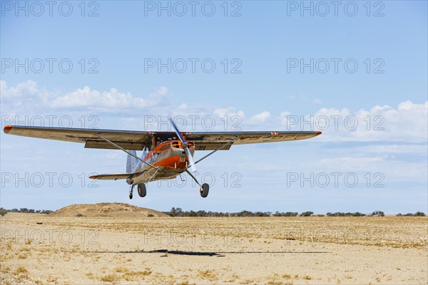 Cessna 170 lands on a sandy runway