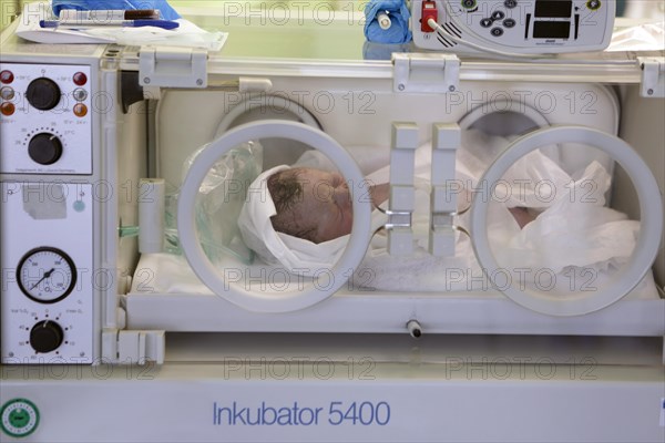 Newborn lying in incubator